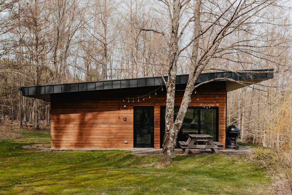 a small cabin in the woods with a picnic table