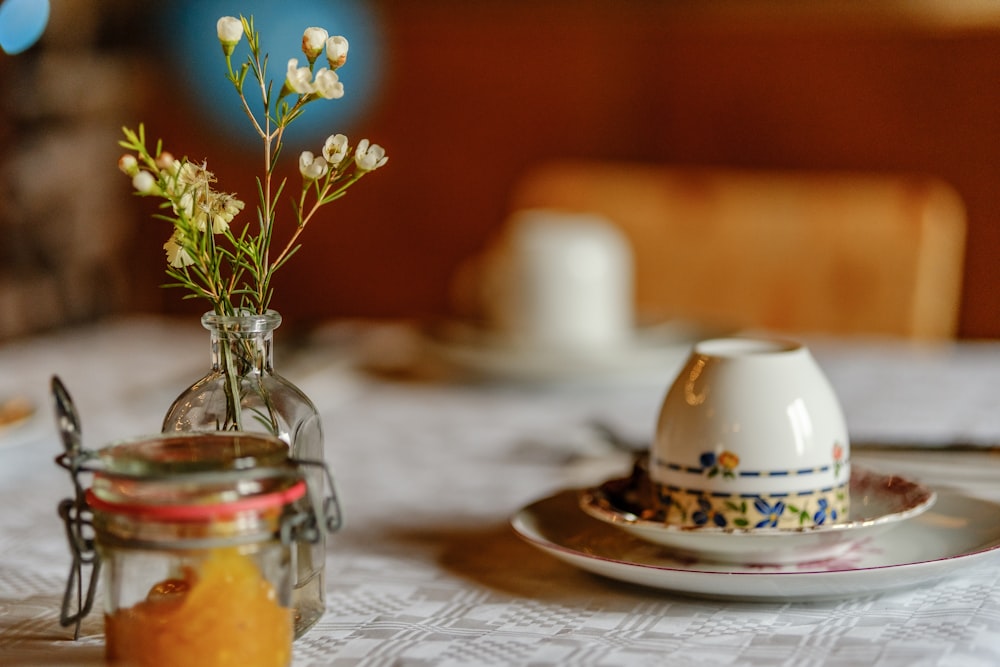 a table with a plate and a vase with flowers in it