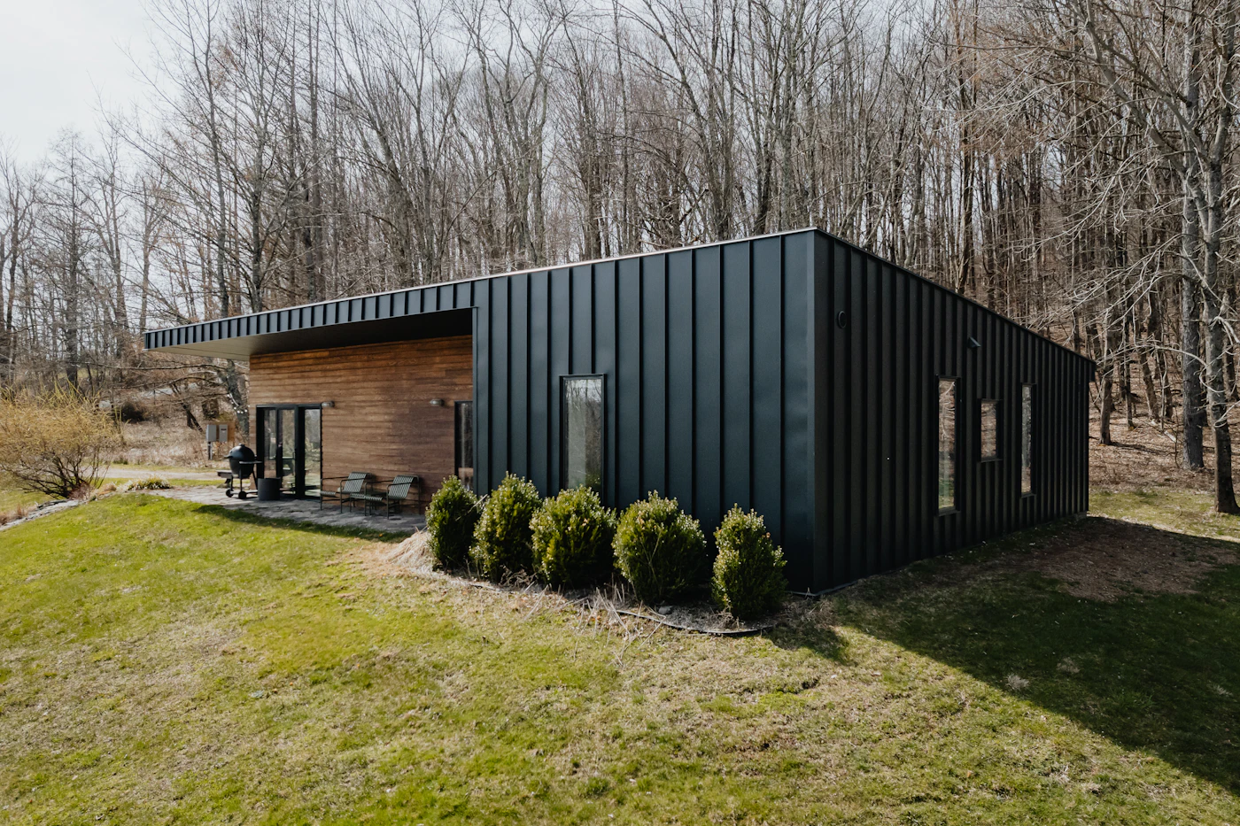 Modern black modular cabin set in an open field