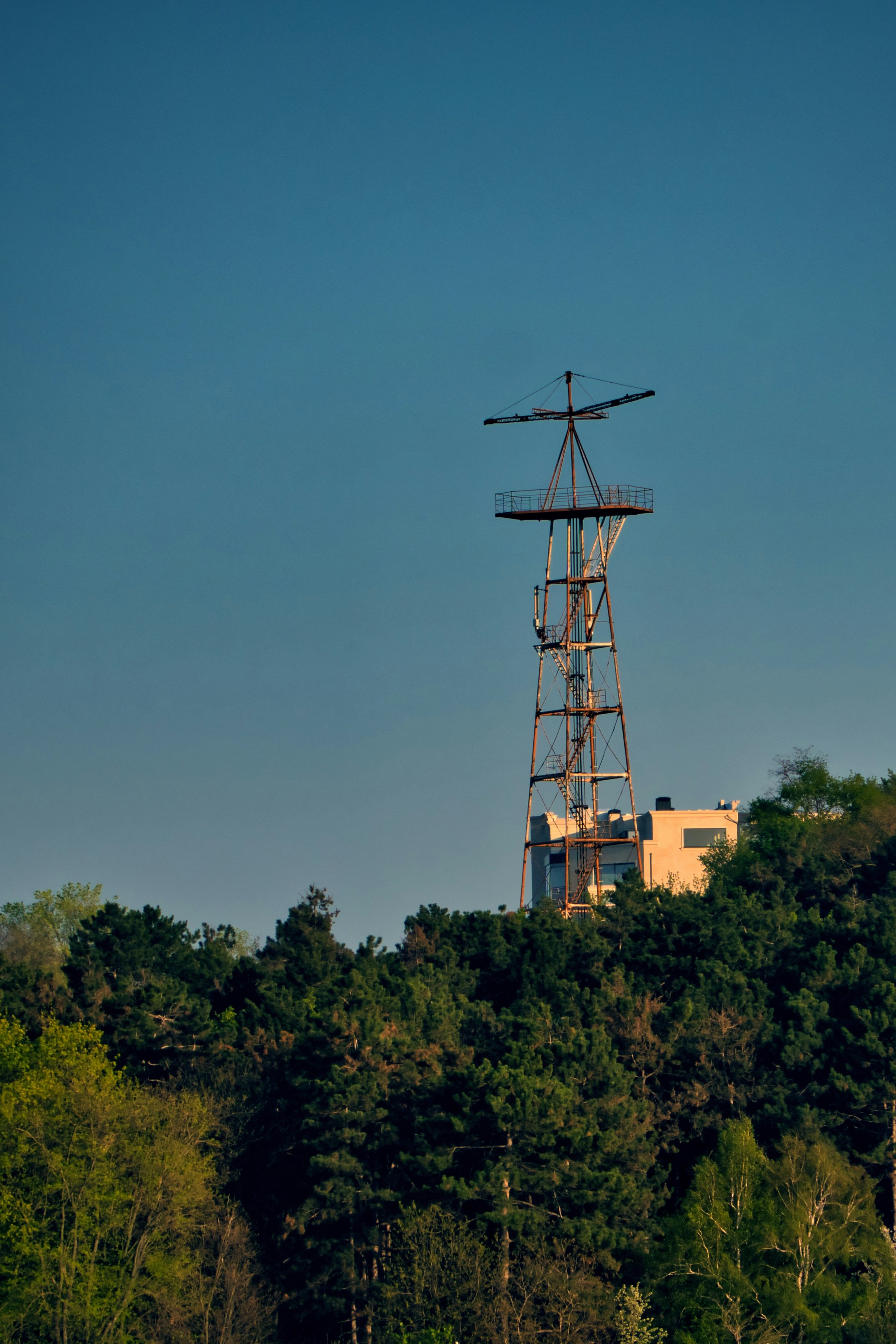 un moulin à vent au sommet d’une colline avec un bâtiment en arrière-plan