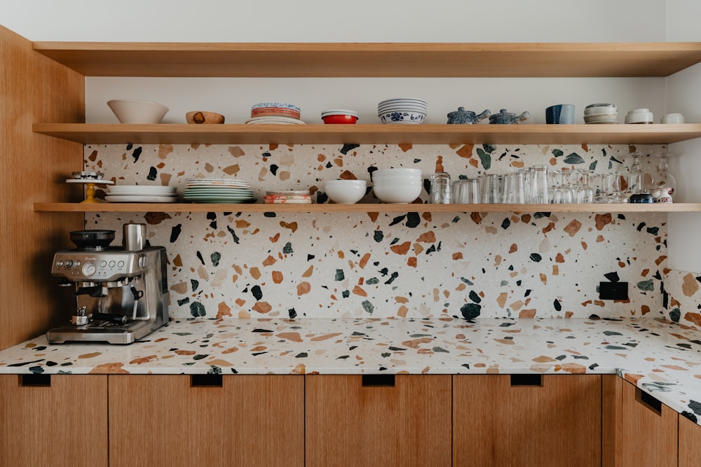 a kitchen counter with a coffee maker and cups on it