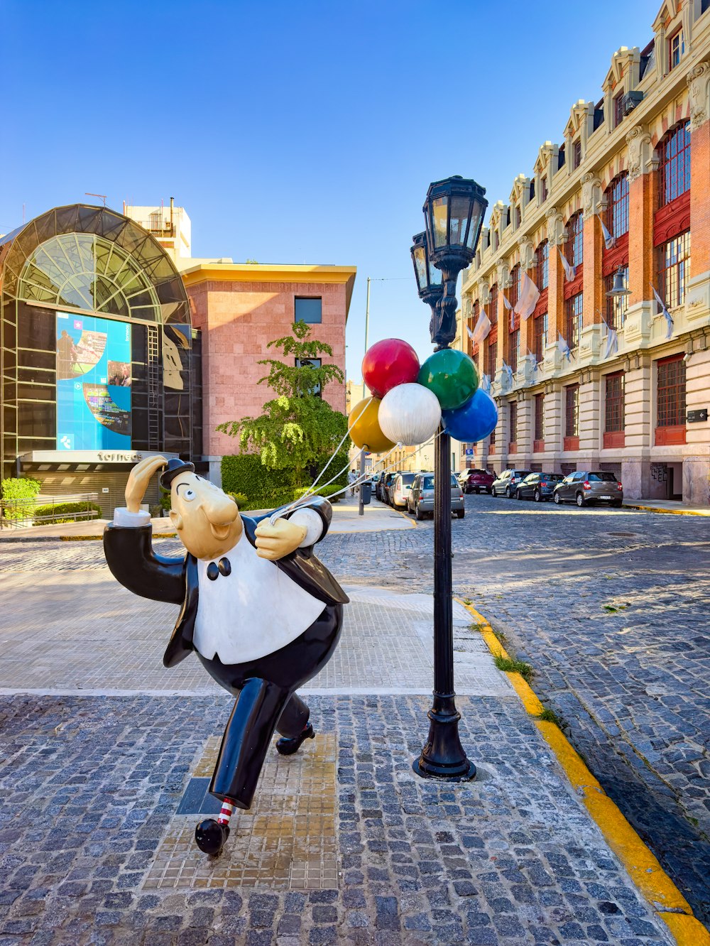 a statue of a man holding a bunch of balloons