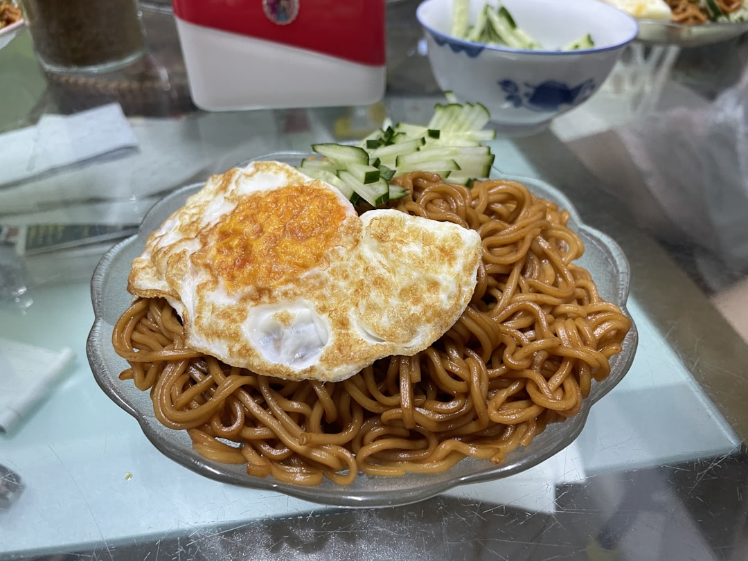 a plate of noodles with an egg on top