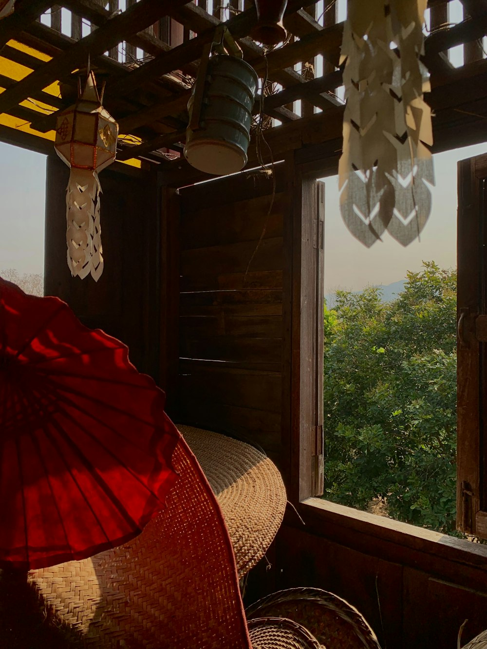 a room with an open window and a red umbrella