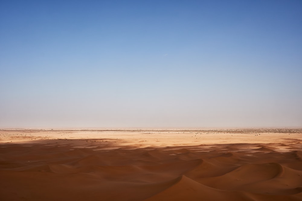 a desert landscape with a blue sky in the background