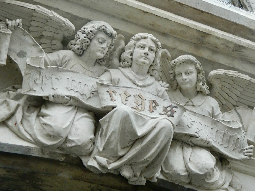 a close up of a statue of angels on a building