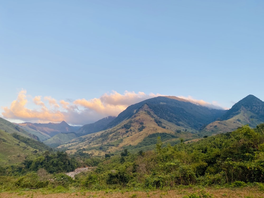 a scenic view of a mountain range with clouds in the sky