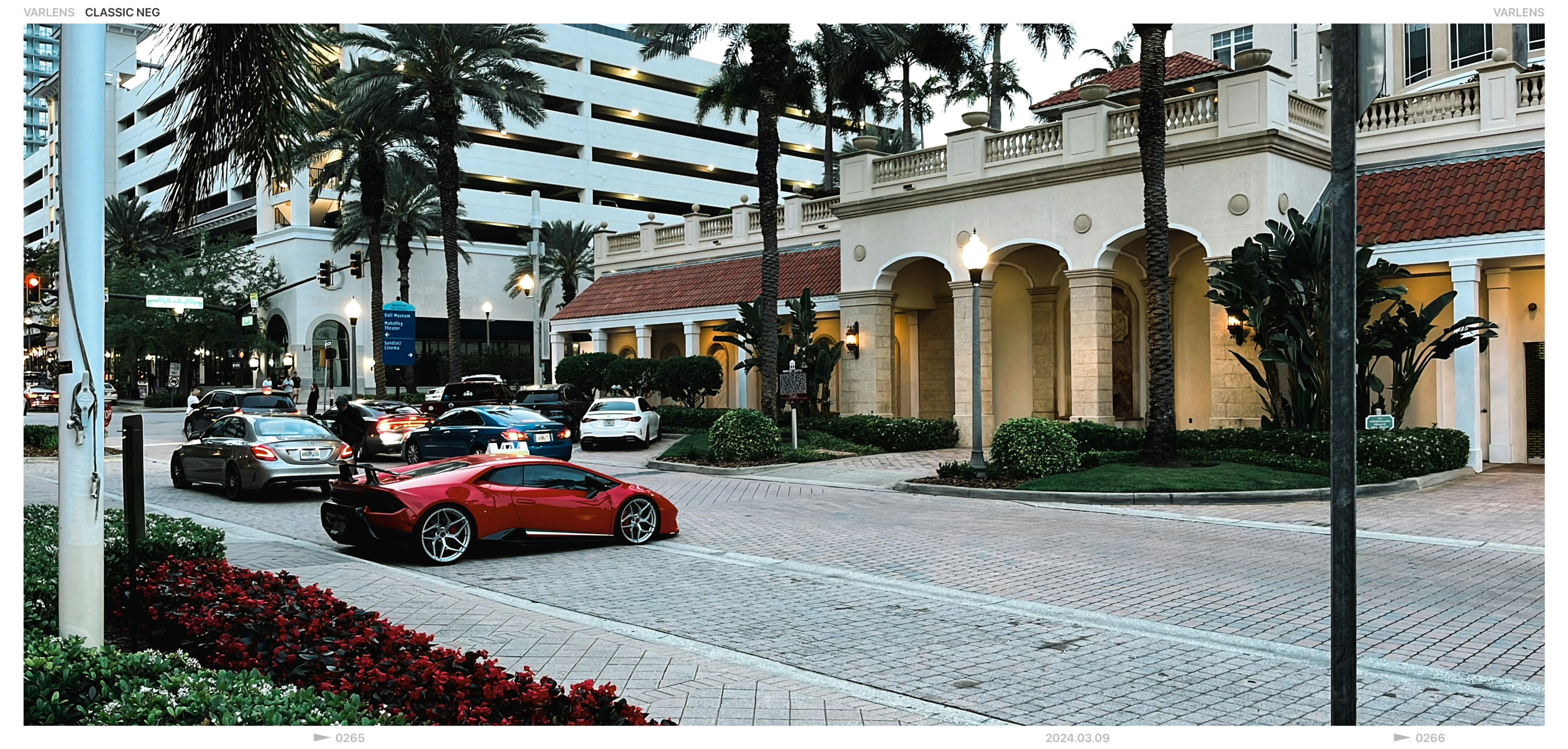 a red sports car driving down a street next to tall buildings