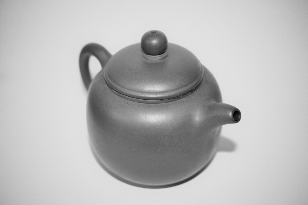 a teapot is sitting on a white surface