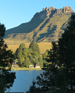 a lake surrounded by trees with a mountain in the background
