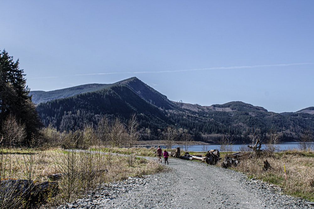 a group of people walking down a dirt road