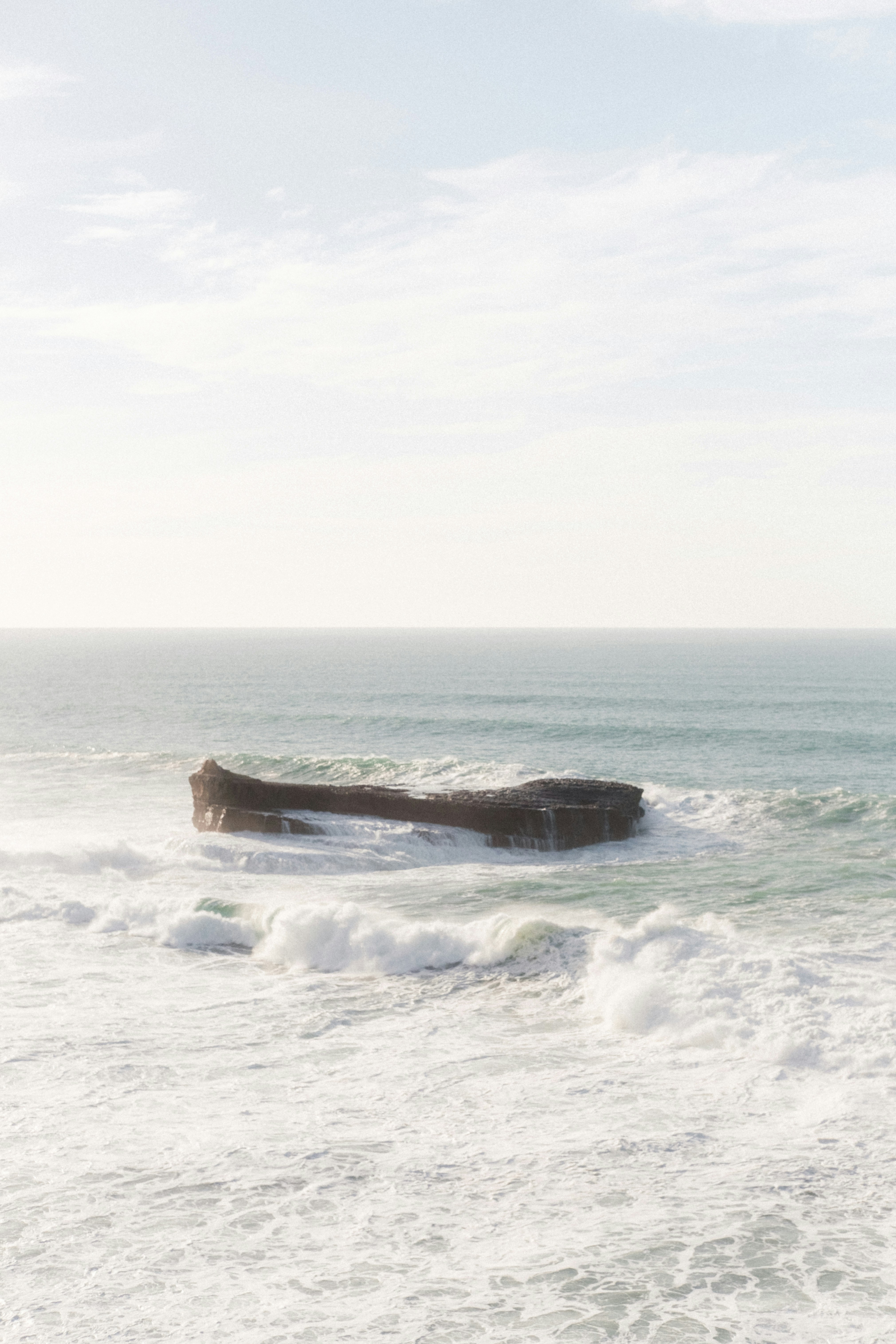 Un gros rocher sortant de l’océan photo – Photo Gris Gratuite sur Unsplash