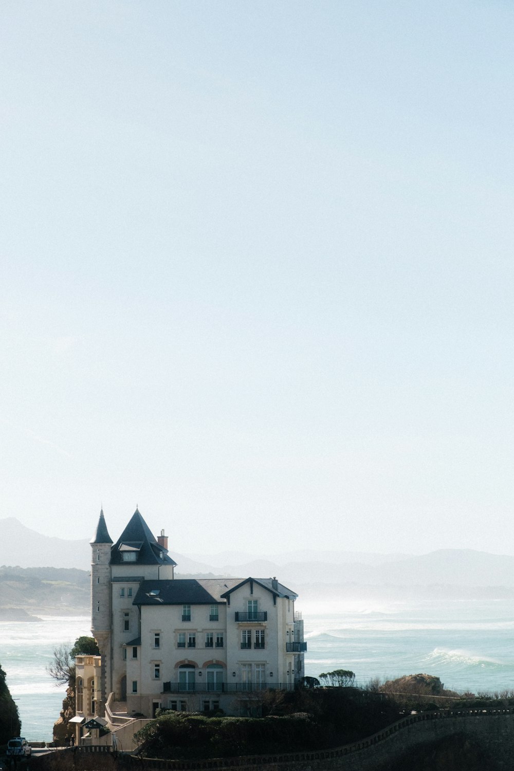 a large white castle sitting on top of a hill next to the ocean