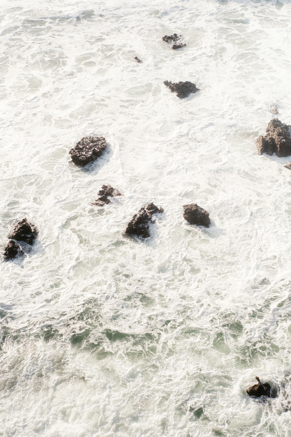 a group of rocks sitting in the middle of a body of water