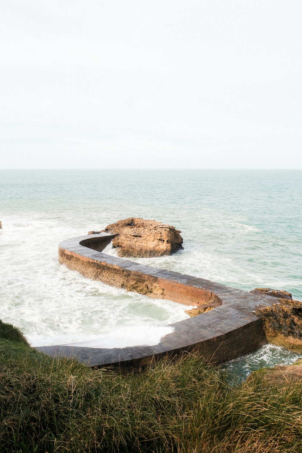 a bench sitting on top of a cliff near the ocean