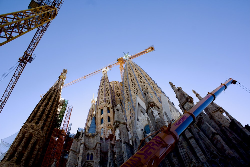 a crane is standing next to a tall building