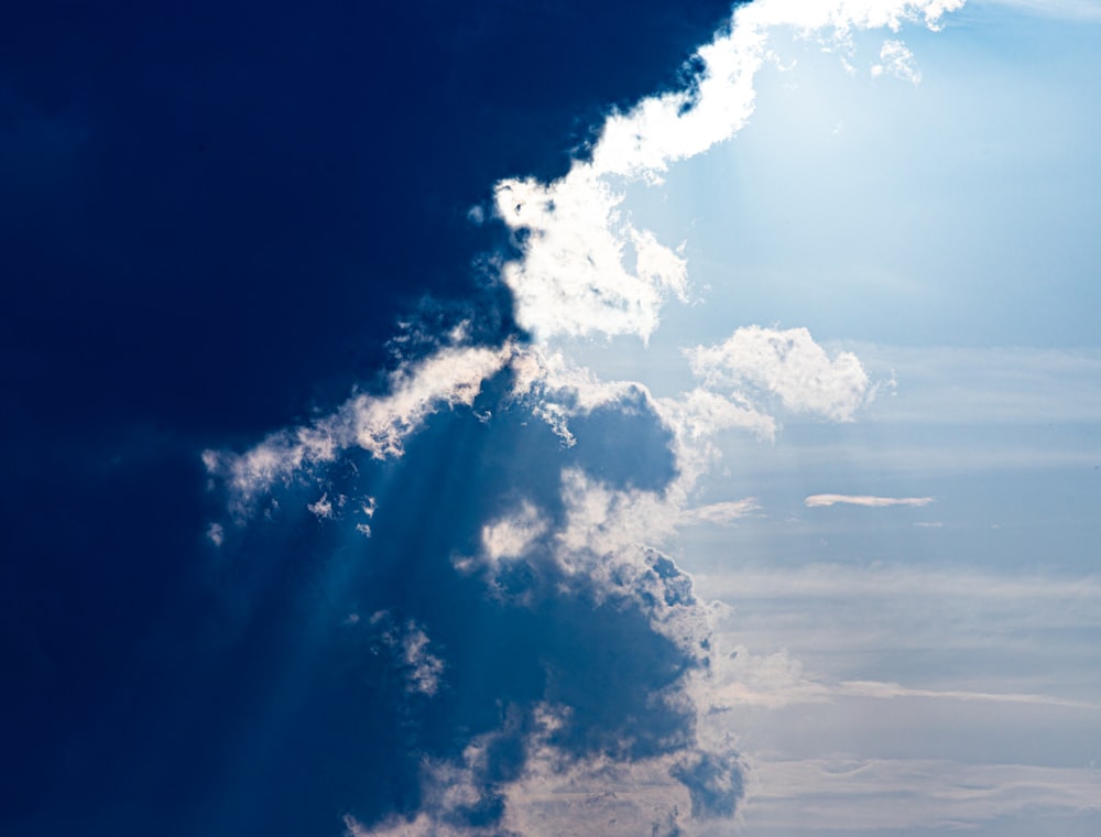 a jetliner flying through a cloudy blue sky