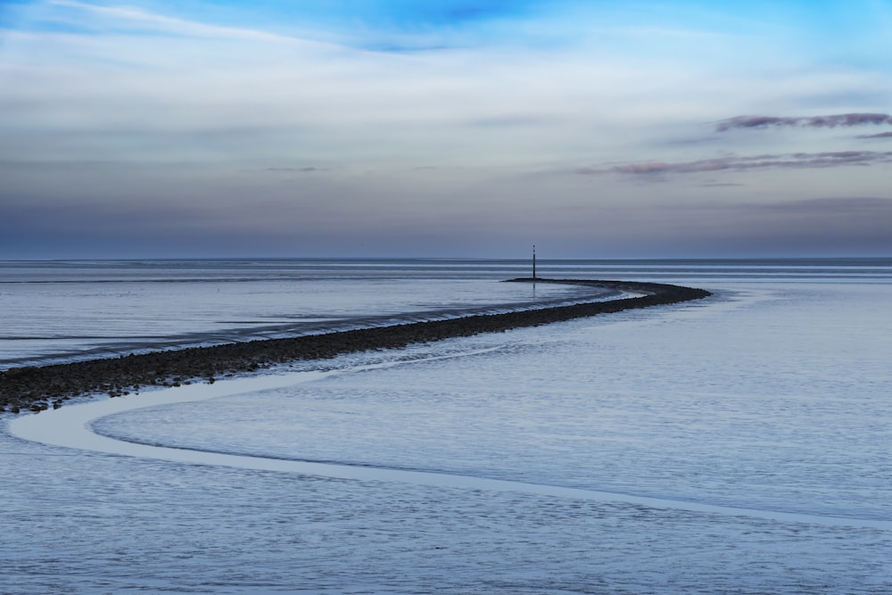 a large body of water sitting under a cloudy sky