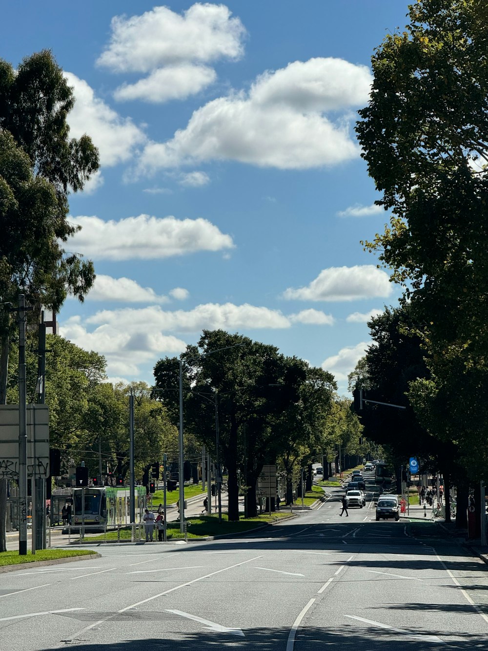 a car driving down a street next to trees