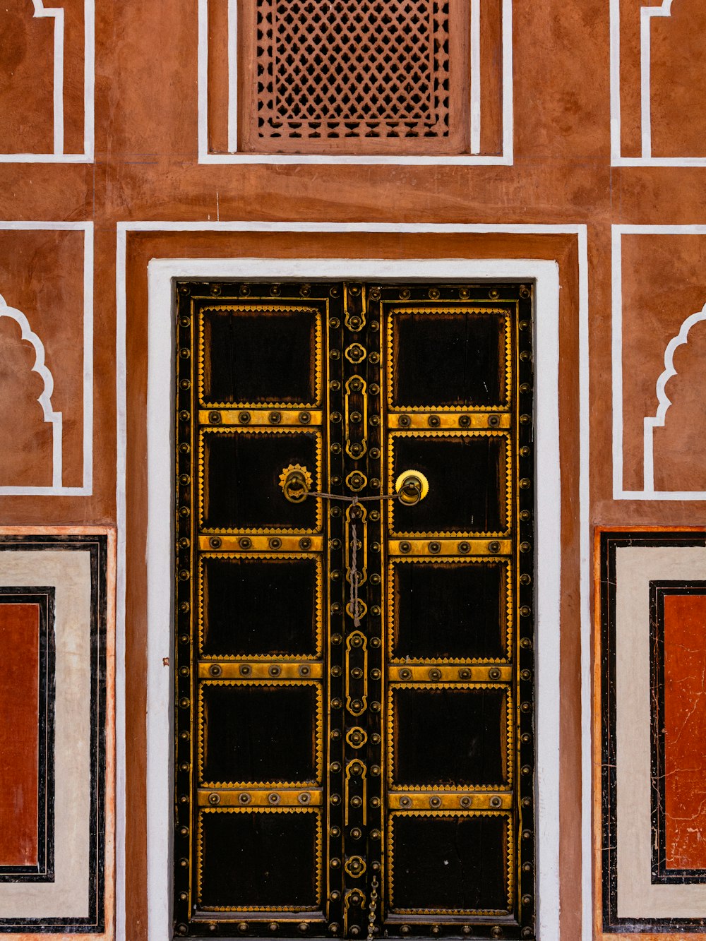 a black and gold door with a clock on the side of it