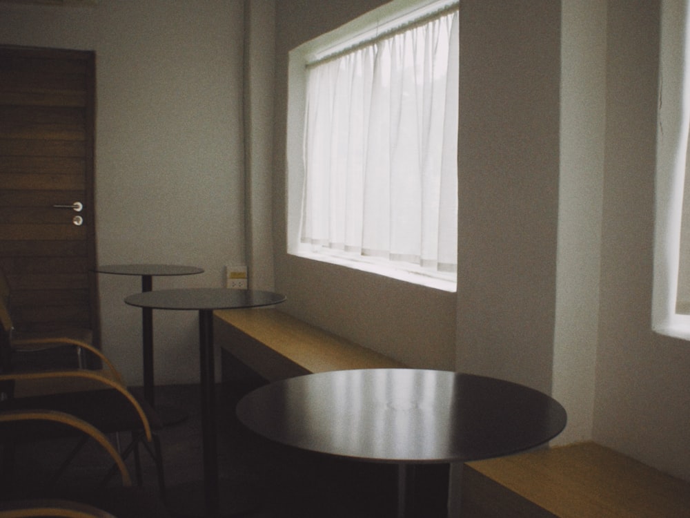 a room with a table, chairs and a window