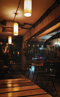 a dimly lit restaurant with wooden tables and chairs