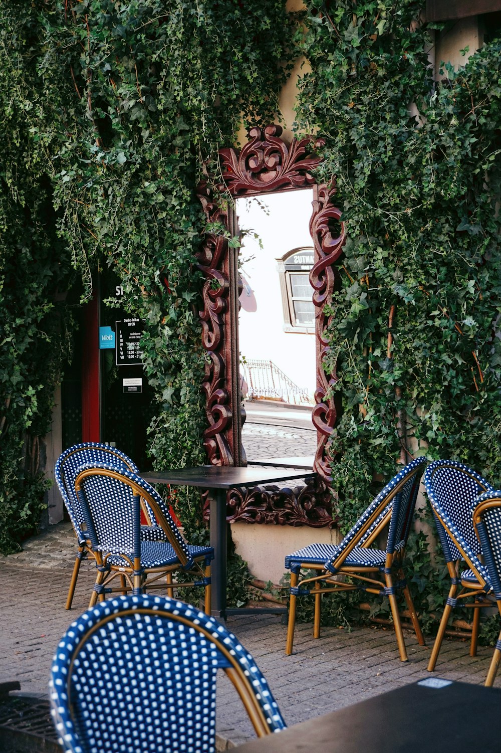 a table with blue chairs and a mirror on the wall