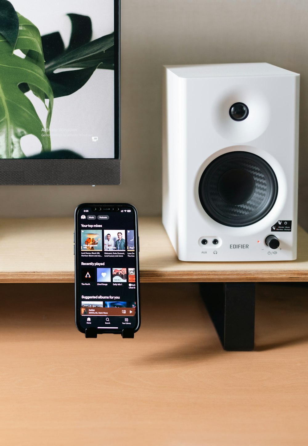 a cell phone sitting on top of a desk next to a computer monitor