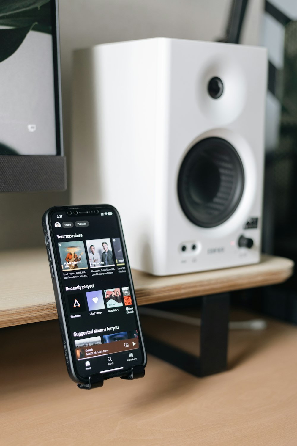 a cell phone sitting on top of a desk next to a speaker