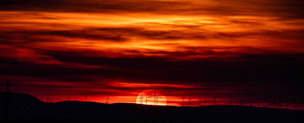 el sol se está poniendo sobre una cadena montañosa