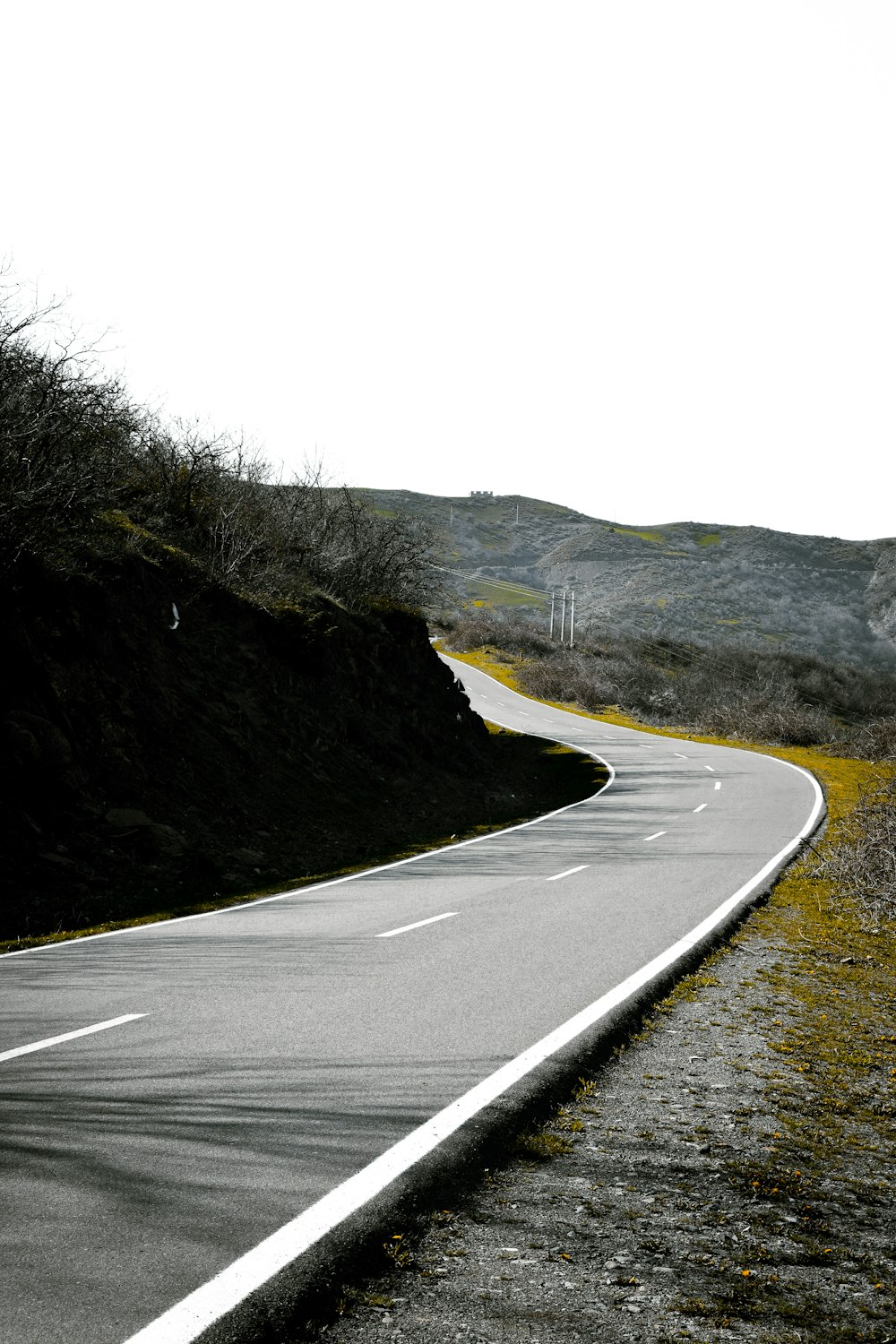 a curved road in the middle of a hilly area
