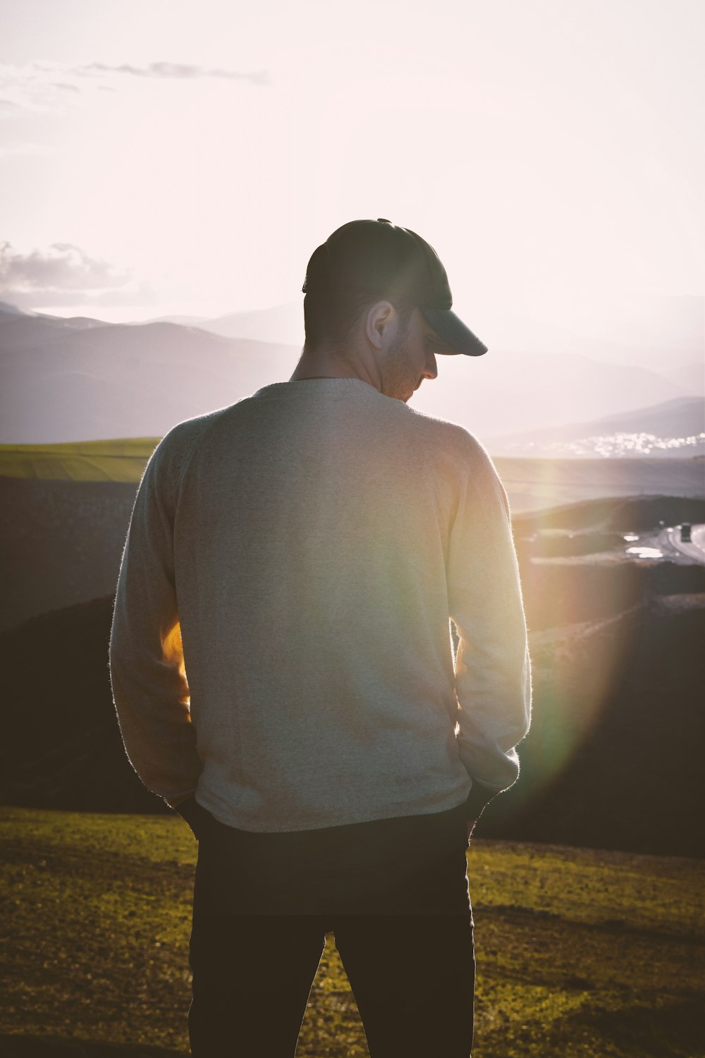 a man standing in a field at sunset