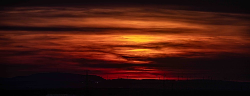 el sol se está poniendo sobre una cadena montañosa