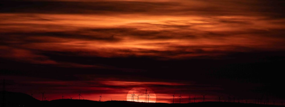 Die Sonne geht am Himmel über einem Hügel unter