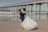 a bride and groom kissing on the beach