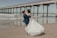 a bride and groom kissing on the beach
