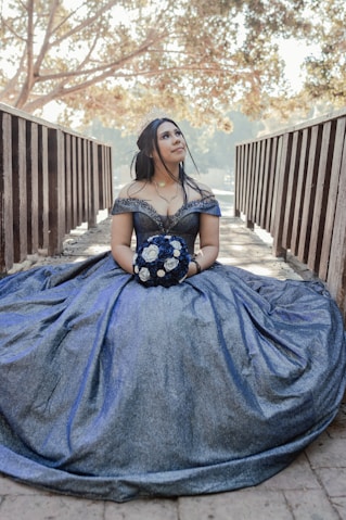 a woman in a blue dress sitting on a wooden bench