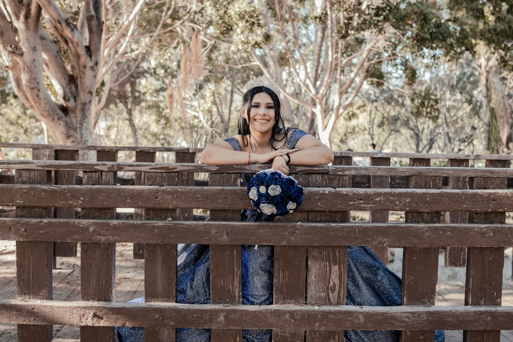 a woman sitting on top of a wooden bench