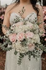 a woman in a wedding dress holding a bouquet of flowers