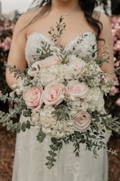 a woman in a wedding dress holding a bouquet of flowers