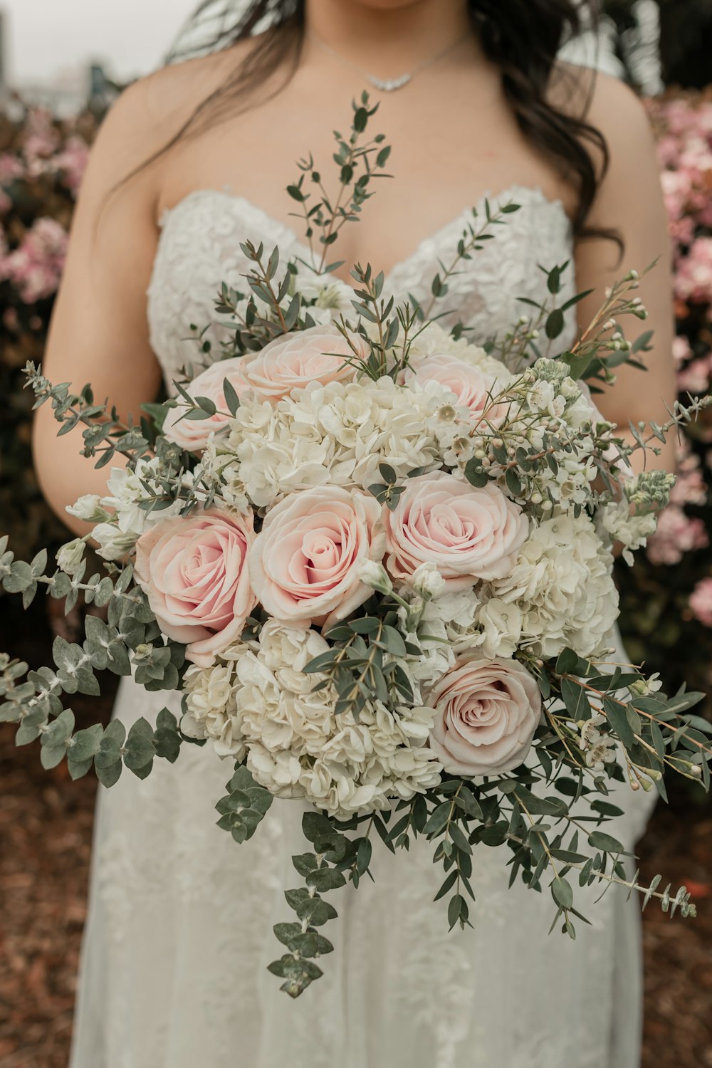 a woman in a wedding dress holding a bouquet of flowers