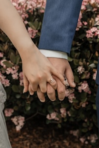 a close up of two people holding hands