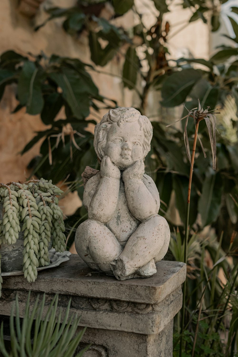 a statue of a child sitting on top of a stone bench