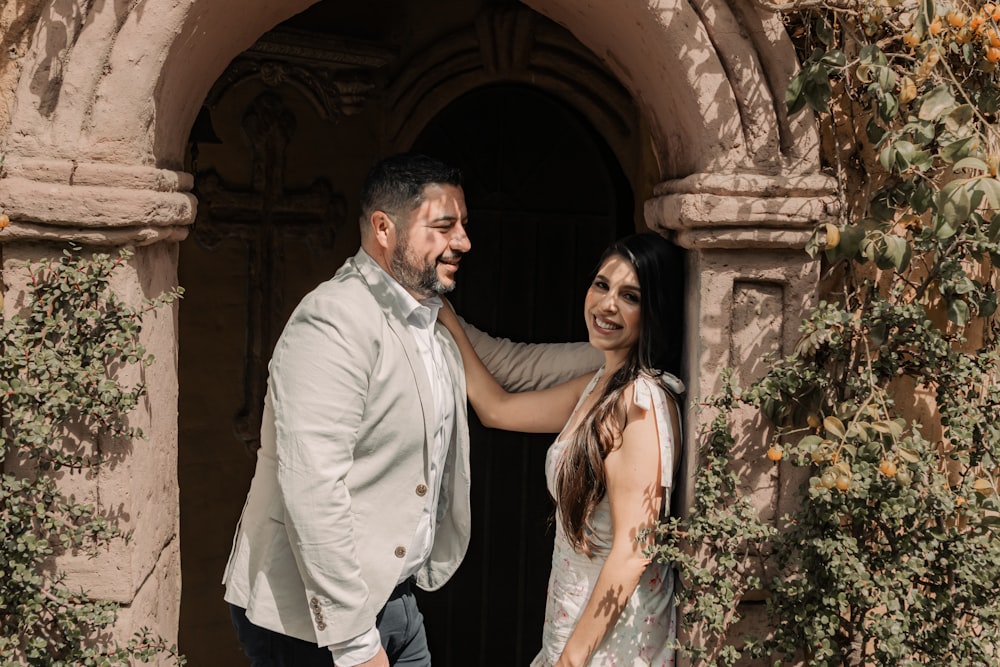 un homme et une femme debout devant une porte