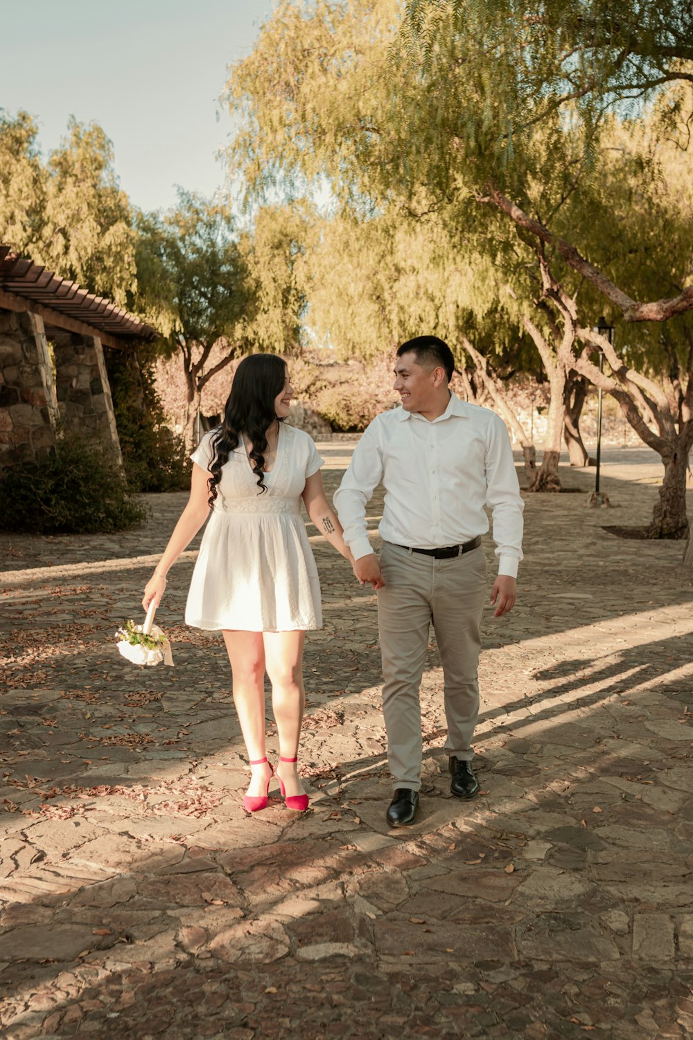 a man and a woman walking down a dirt road