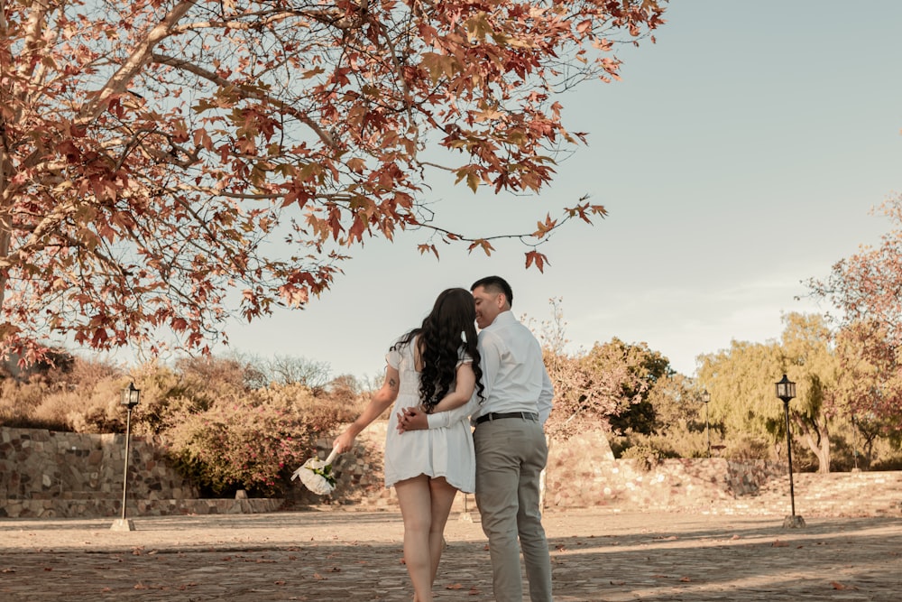 a man and a woman standing under a tree