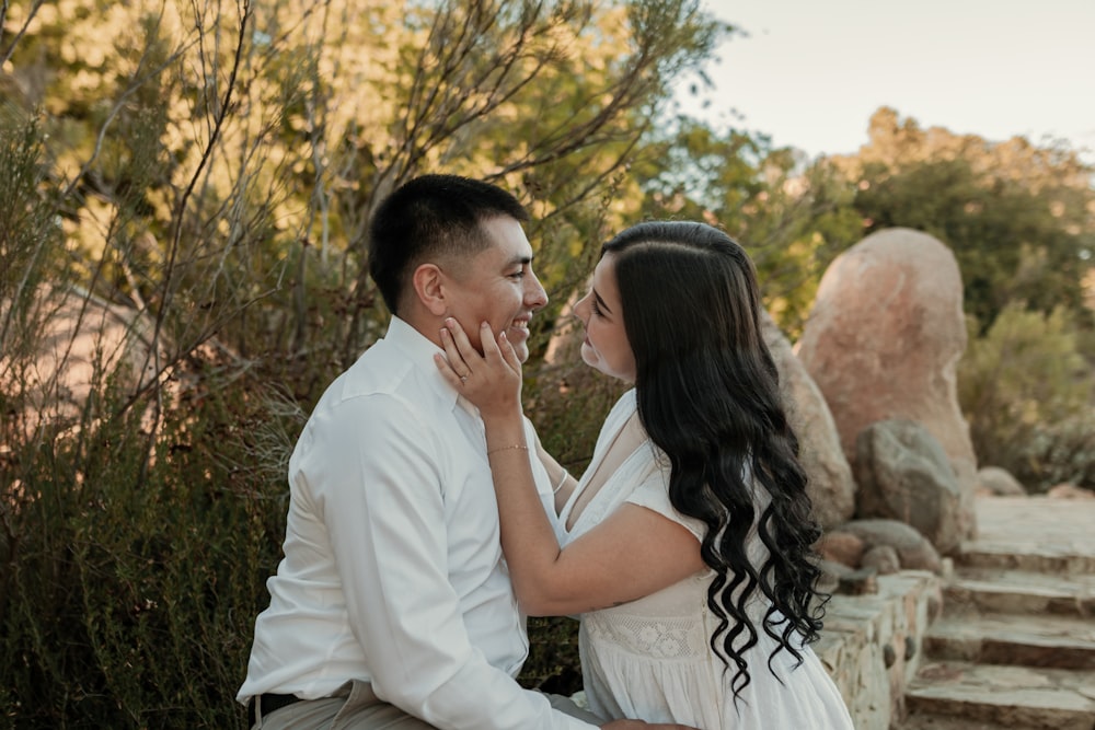 a man and a woman sitting on a stone bench