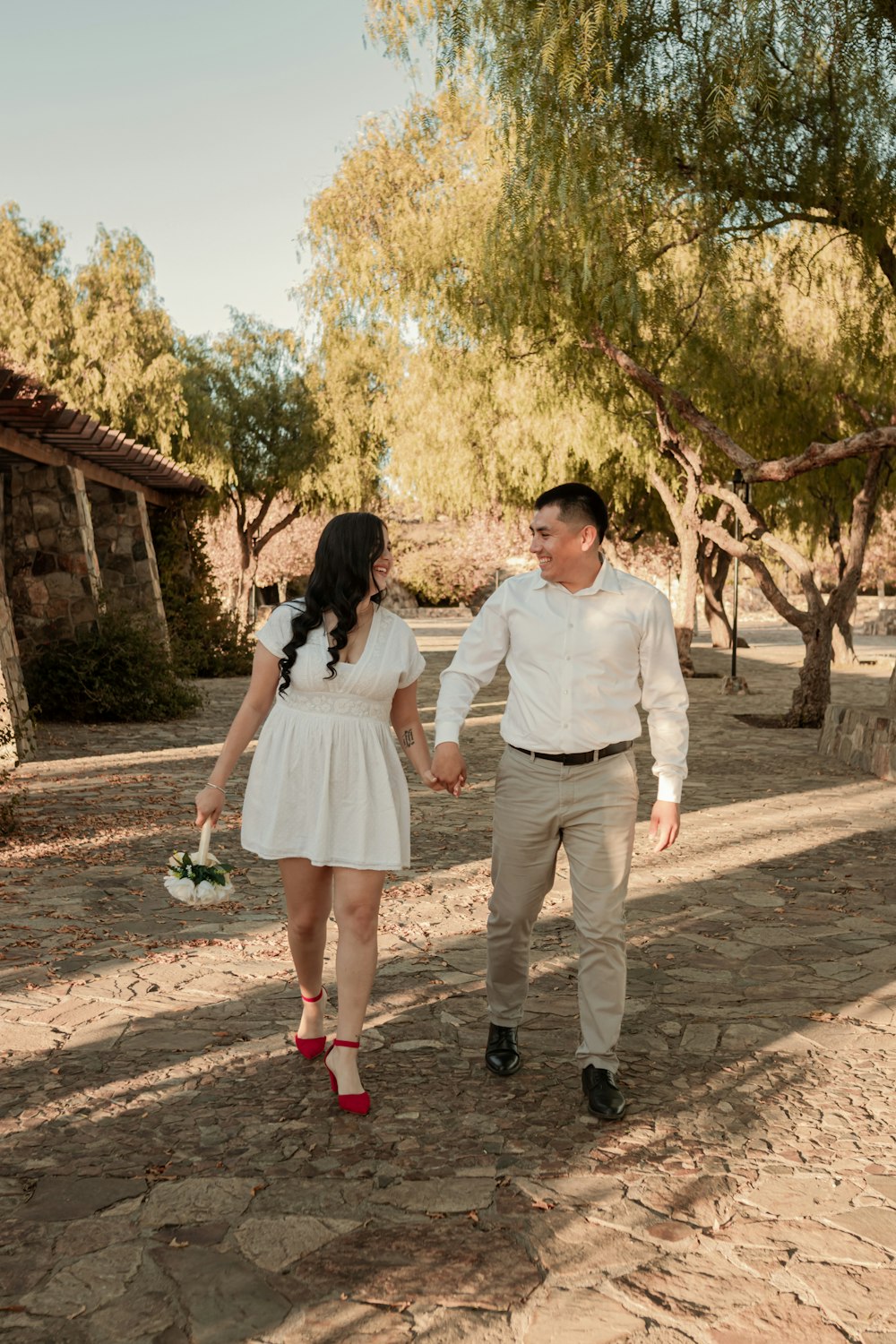 a man and a woman walking down a dirt road