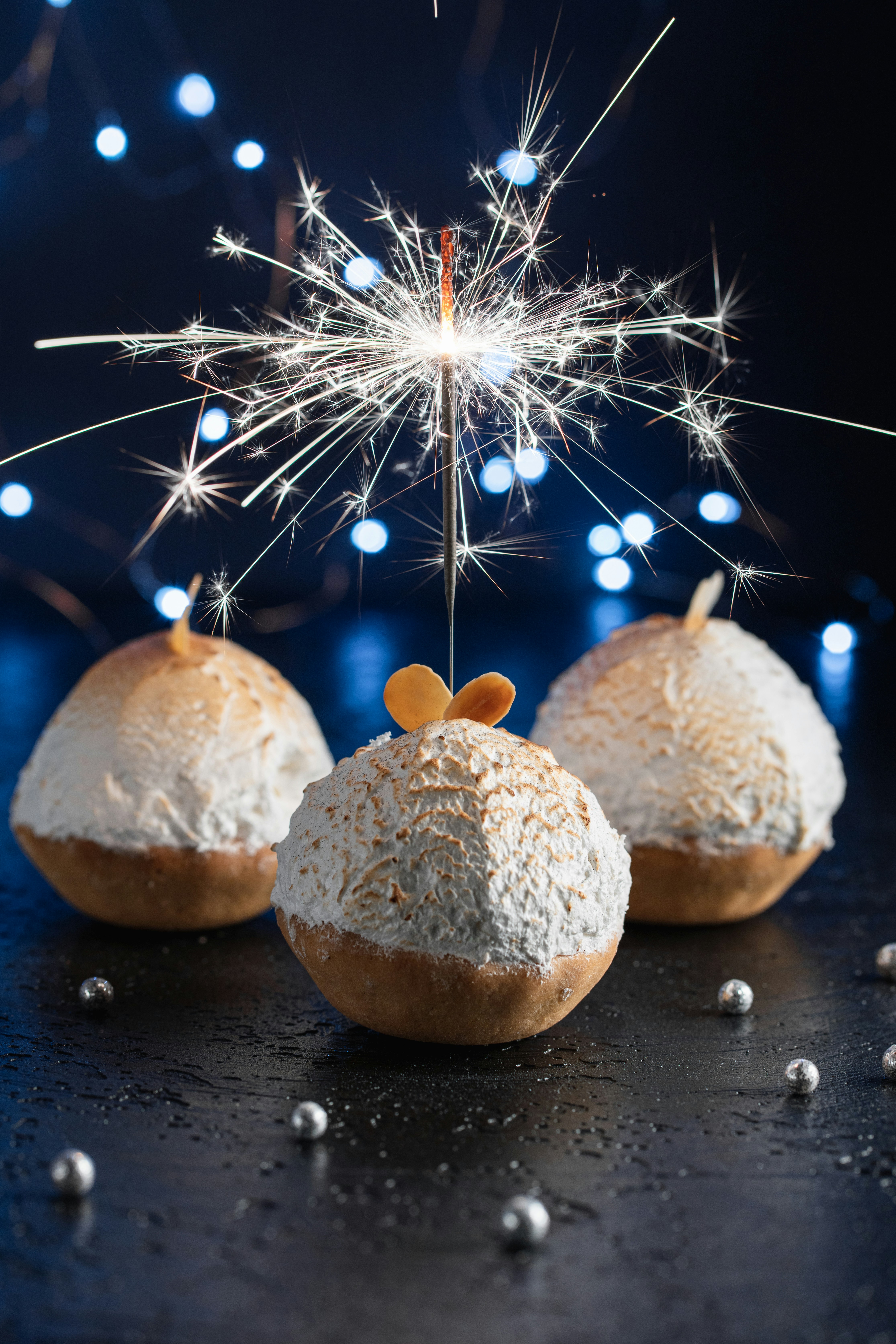 three pastries with a sparkler on top of them