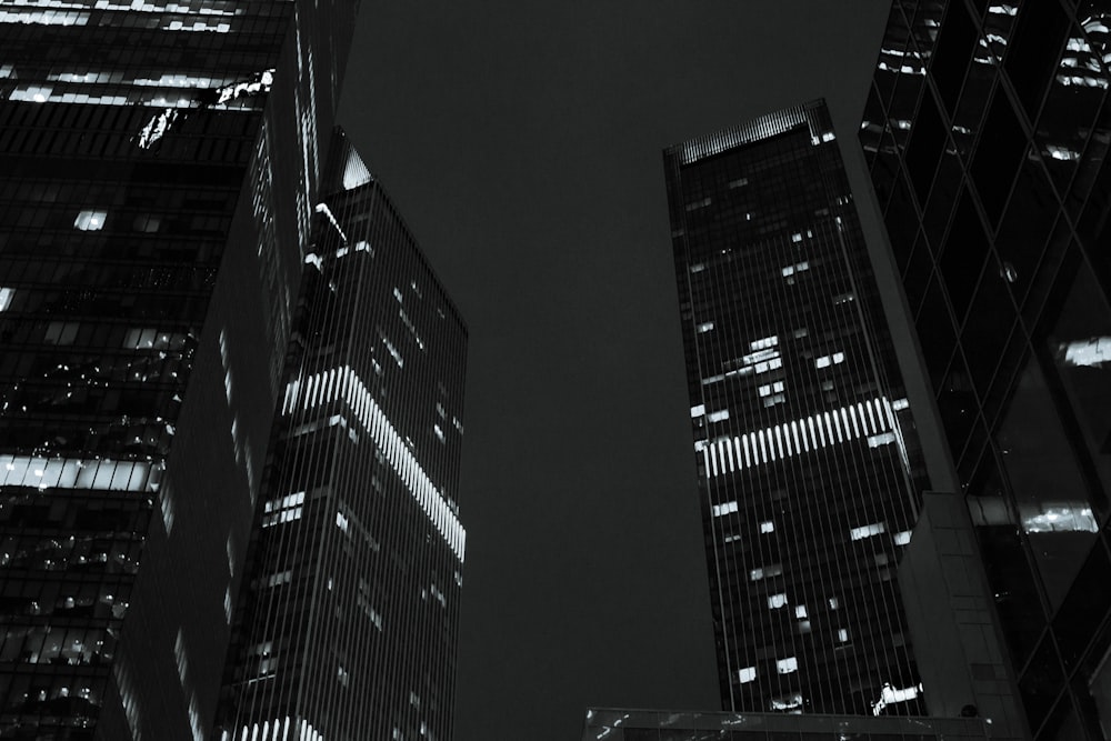 a black and white photo of skyscrapers at night